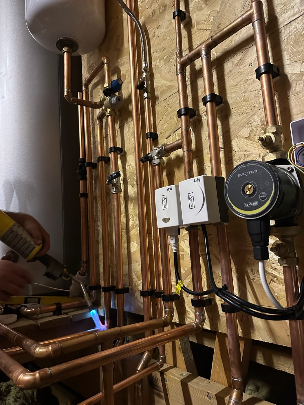 Copper pipework, pump and valves being soldered during a heating installation