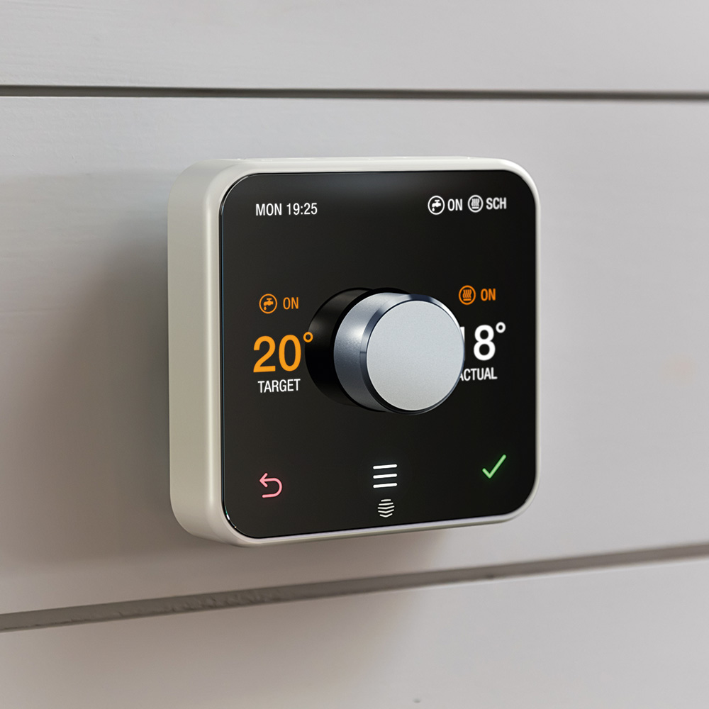 Hive heating control fitted on a wall, showing the target and actual room temperature
