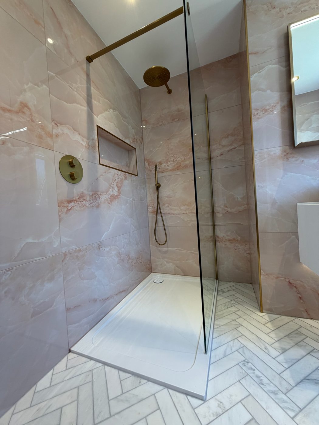 Large walk in shower enclosure with brass shower valve and glass screen