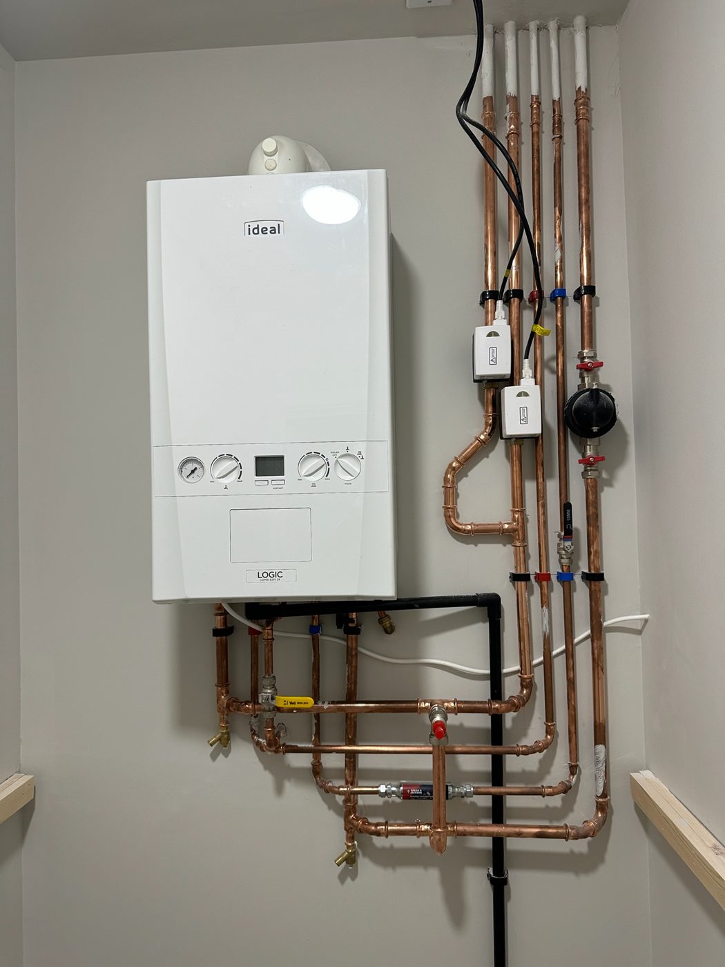 Wall mounted combi boiler with tidy copper pipework beneath it