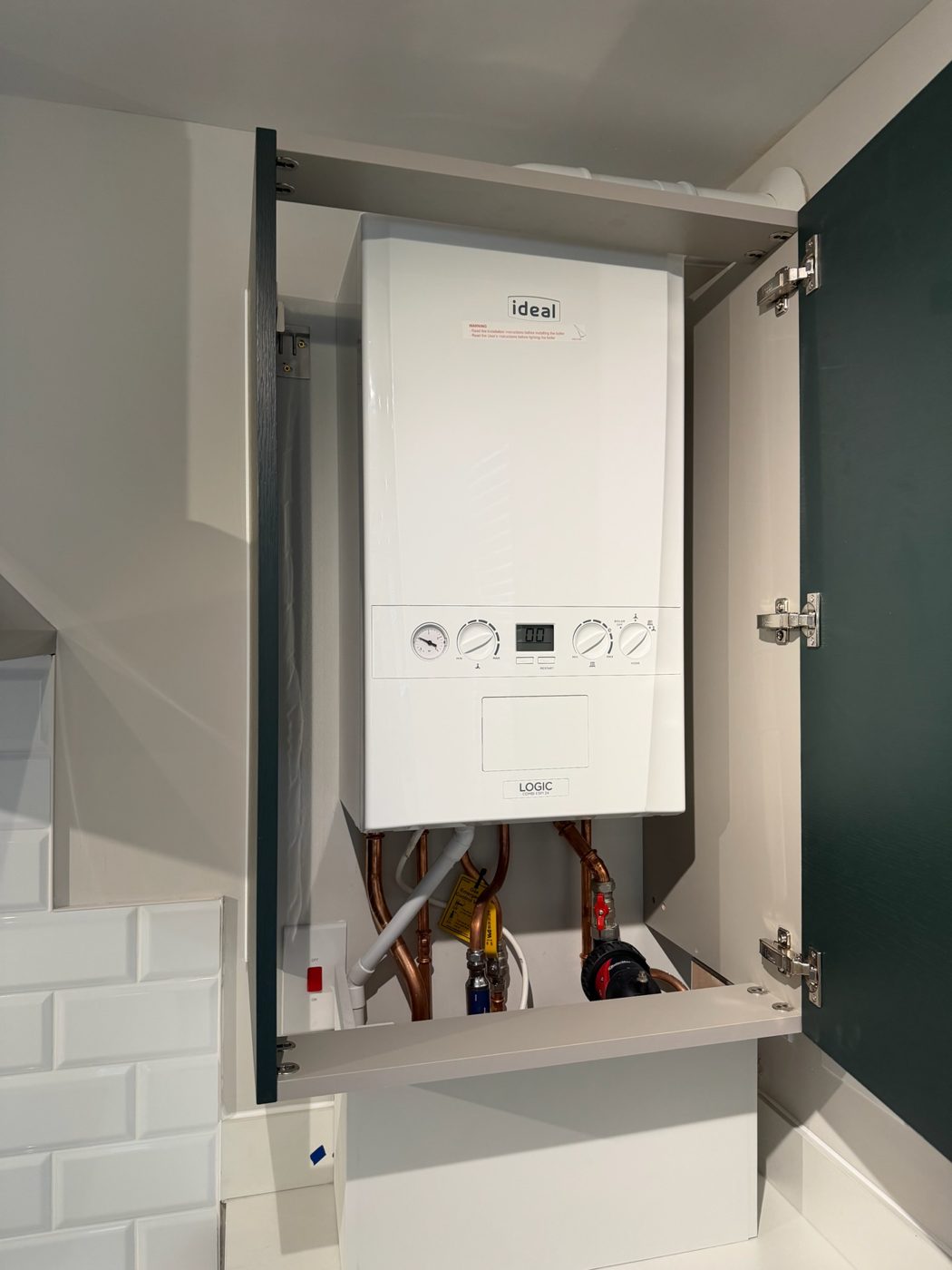 Combi boiler fitted neatly inside a fitted cupboard