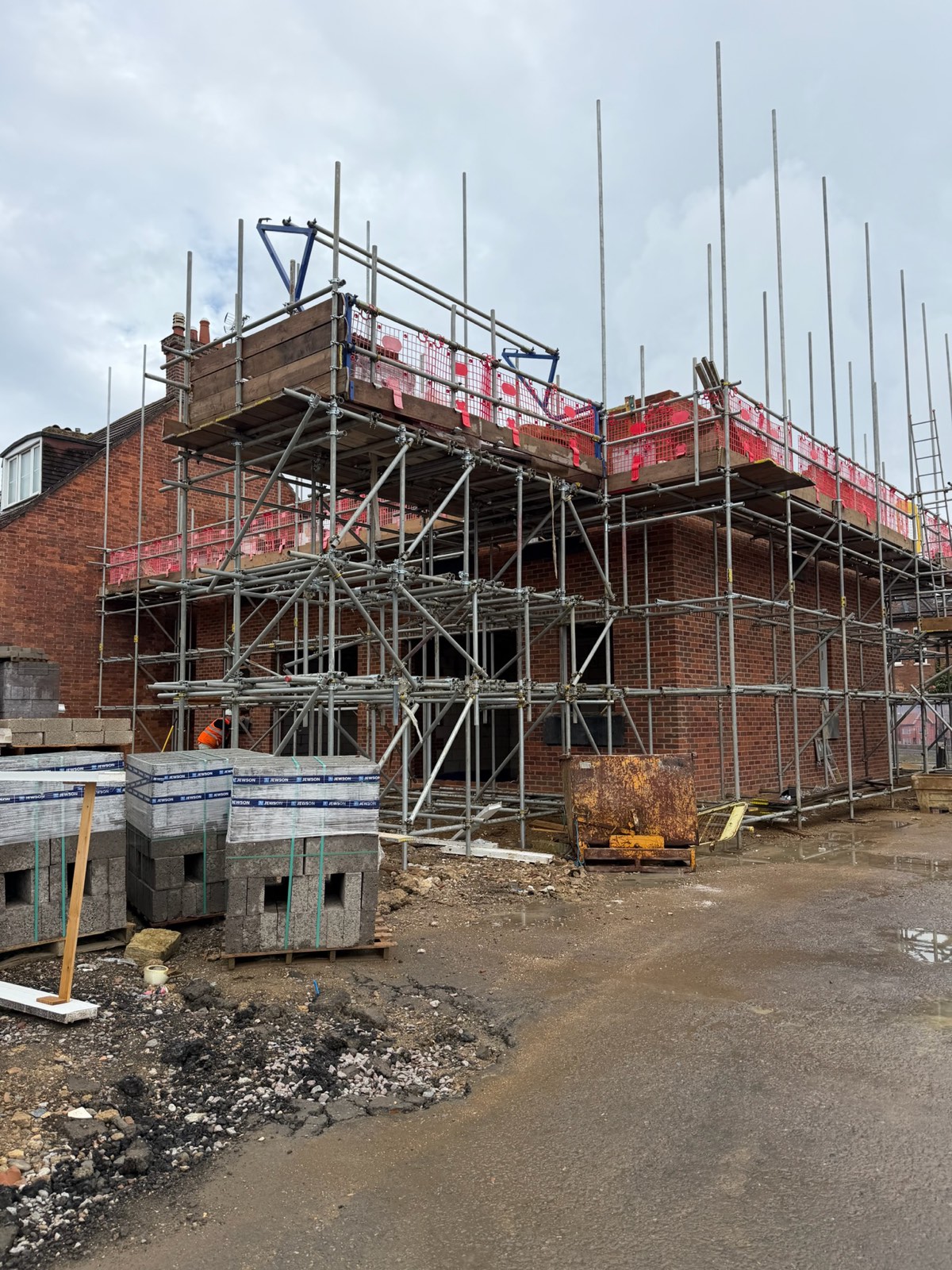 New-build three-storey brick house under scaffold during construction in central Bedford