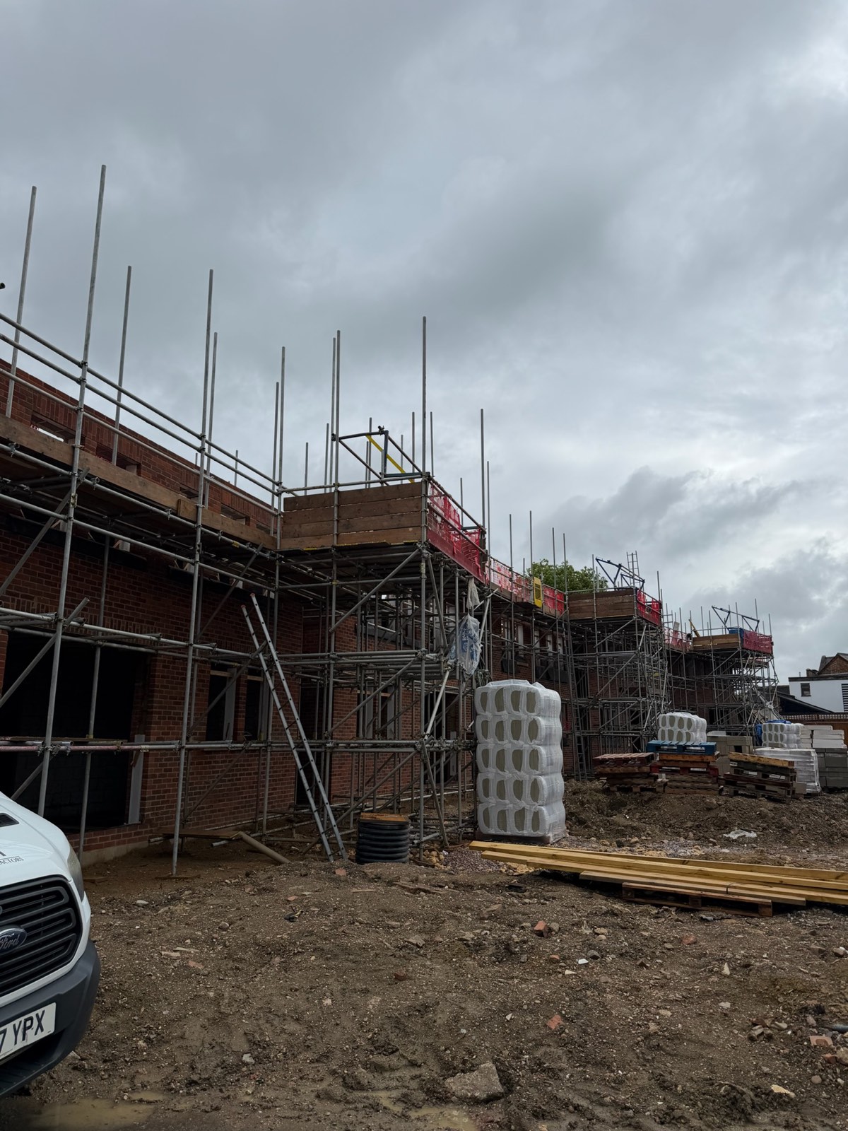 Terrace of new-build brick houses under scaffold on the Bedford development