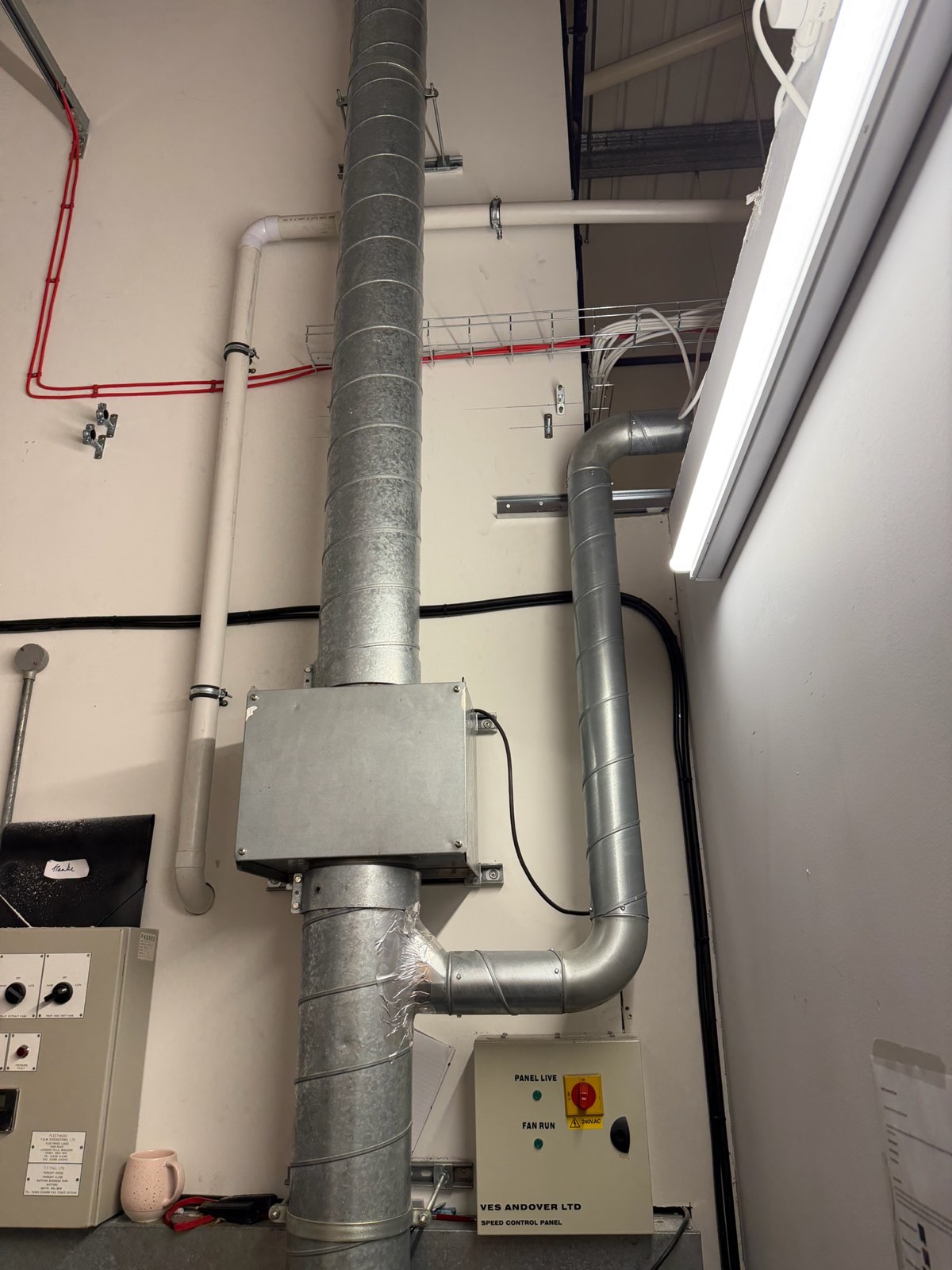 Commercial extract ductwork, fire main and fan speed-control panel in a plant area