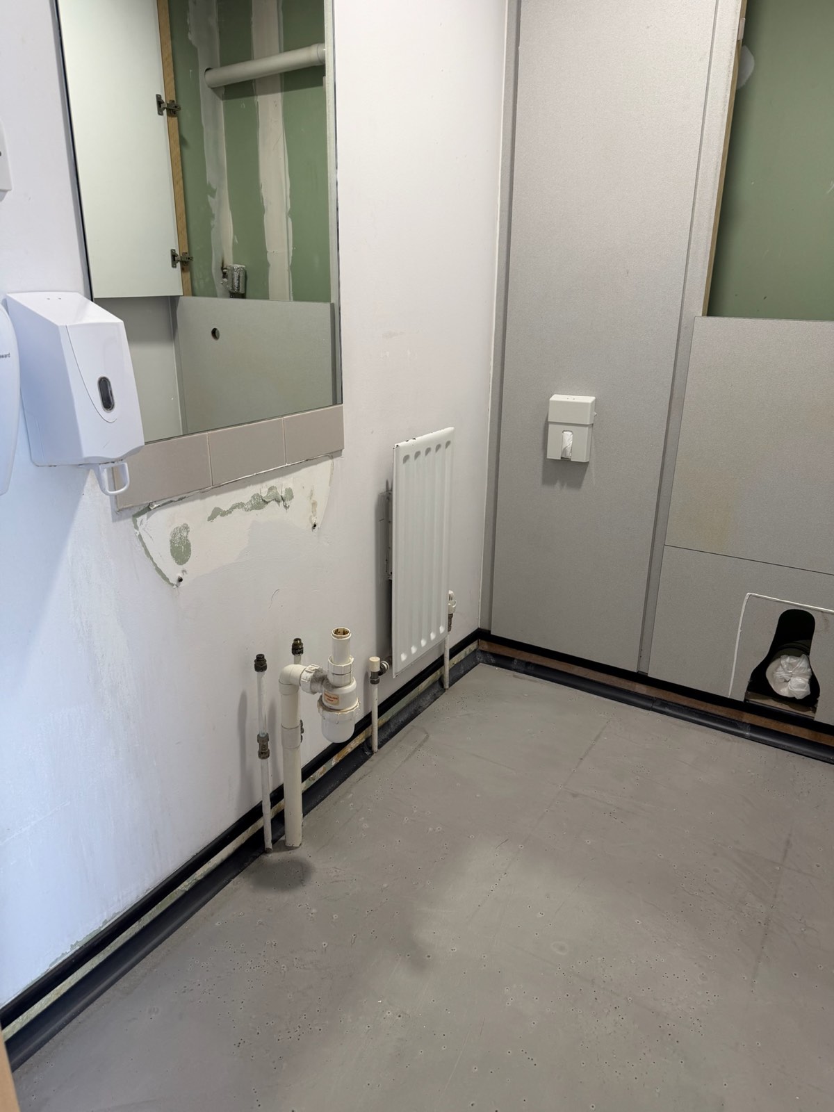 First-fix washroom pipework feeding a basin, radiator and IPS panel ducting