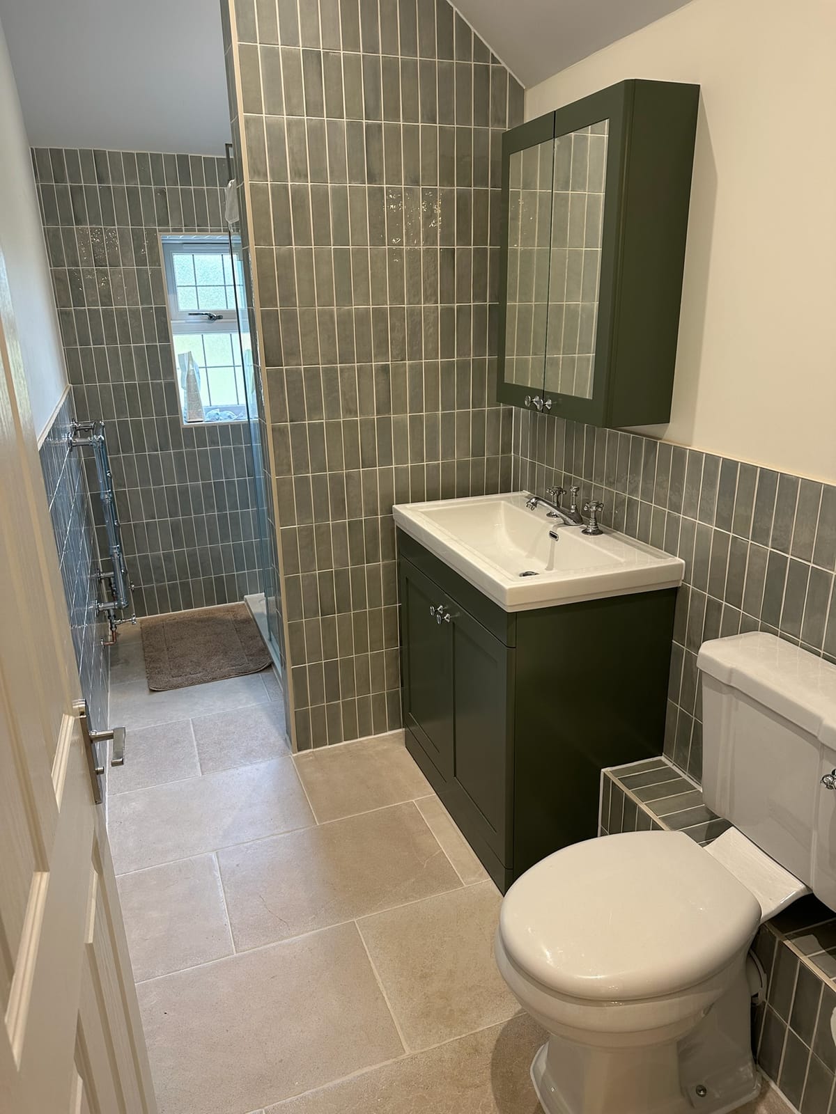 Family bathroom with walk-in shower, painted vanity unit and limestone floor tiling