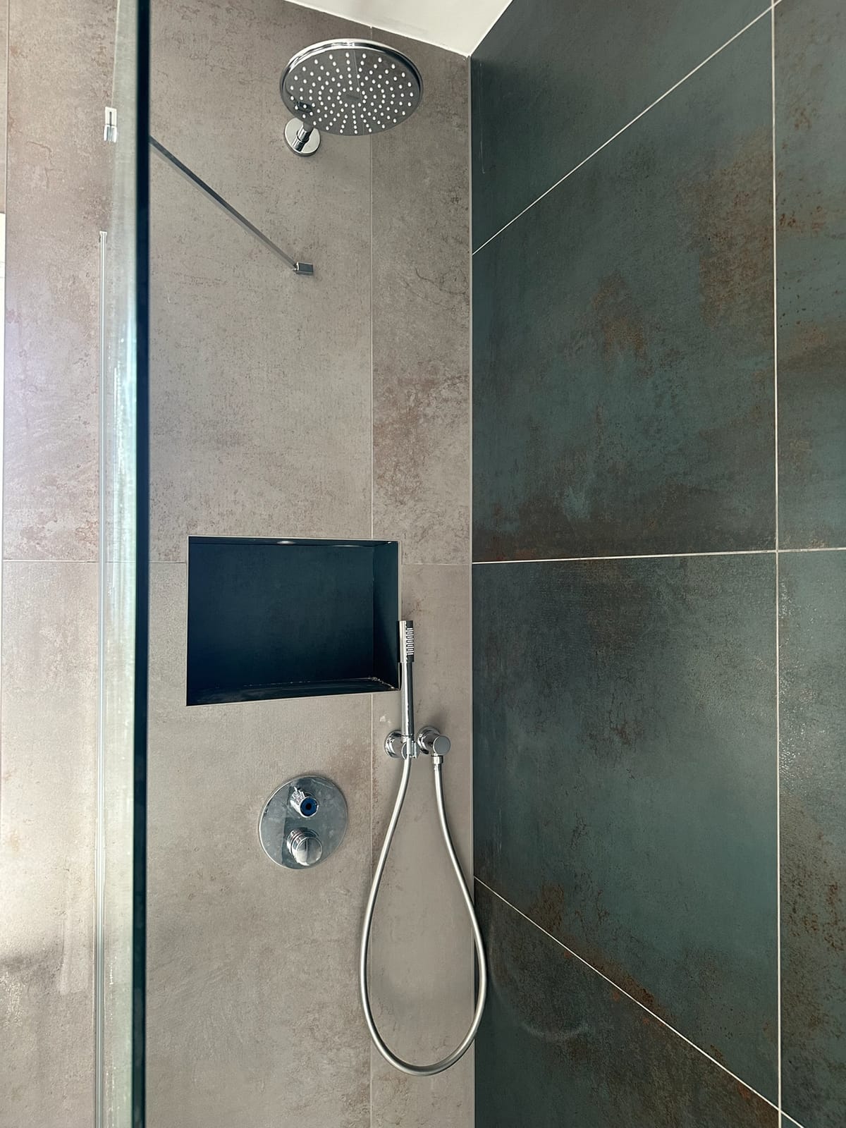 Walk-in shower with a recessed storage niche and ceiling-fed rainfall head
