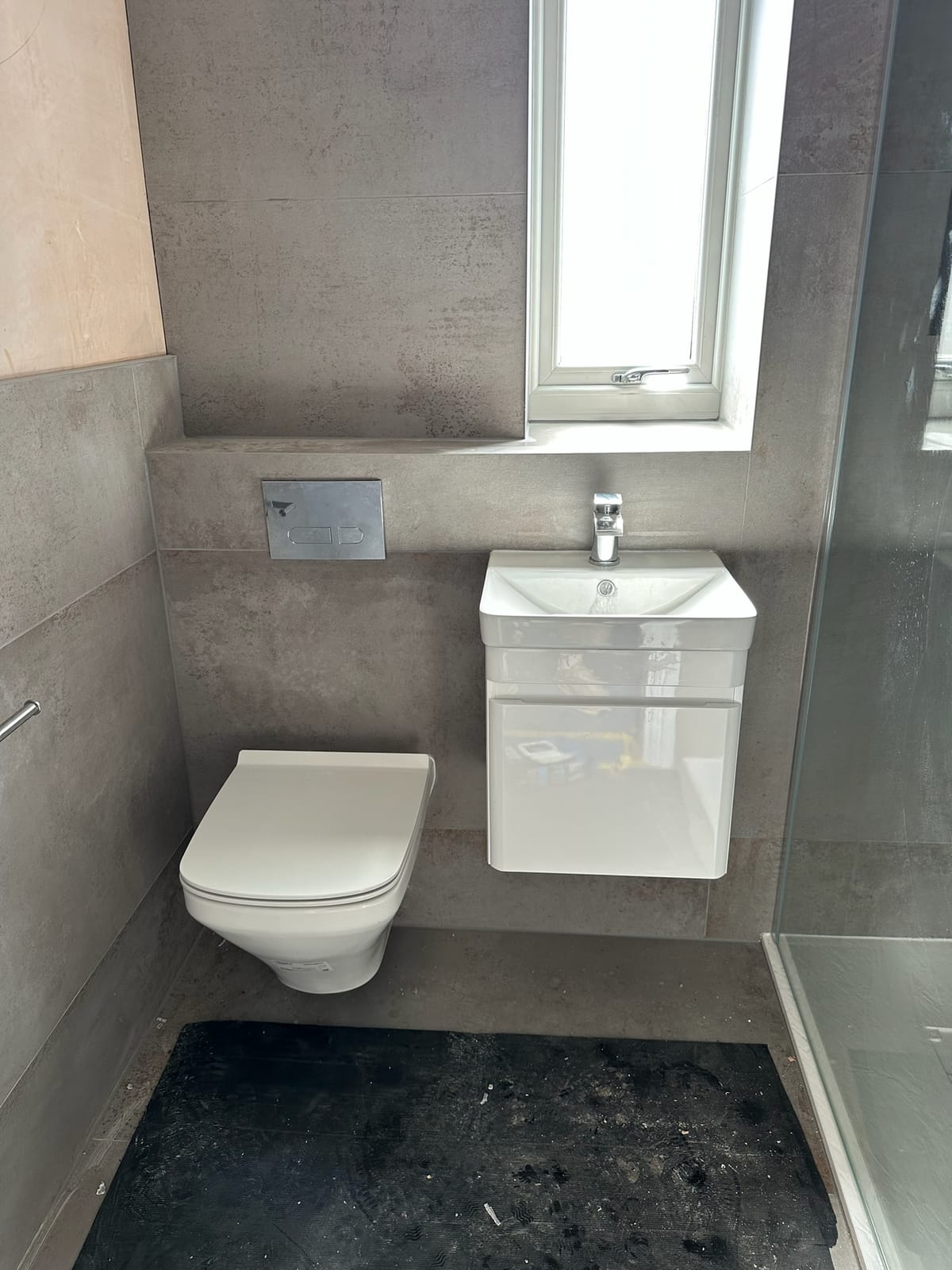 Wall-hung WC and basin mounted on concealed frames with concrete-effect tiling