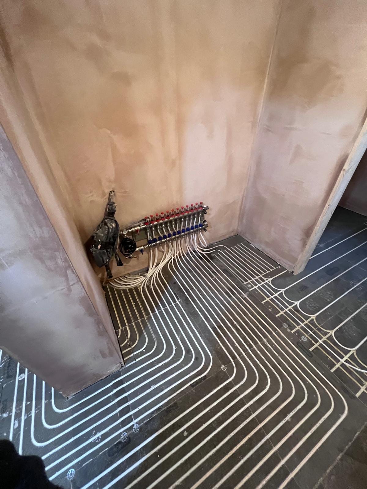 Underfloor heating manifold with circuit runs fanning out across the floor